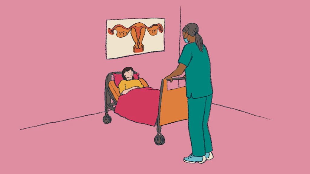 Patientin liegt in einem Spitalbett, eine Pflegekraft steht daneben.