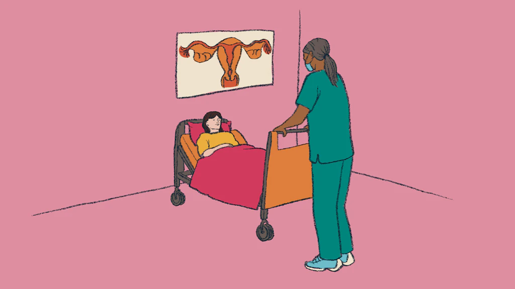 Une patiente est allongée dans un lit d'hôpital, une infirmière se tient à côté d'elle. 